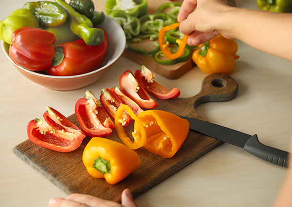 sliced red and orange peppers on a cutting board