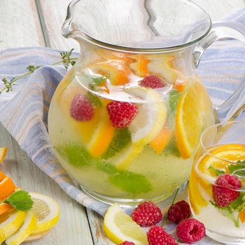 glass pitcher of fruit infused water with sliced fruit