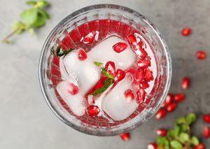 top view of glass filled with ice and pomegranate juice