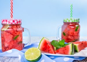 two jars of watermelon infused water next to slices of watermelon