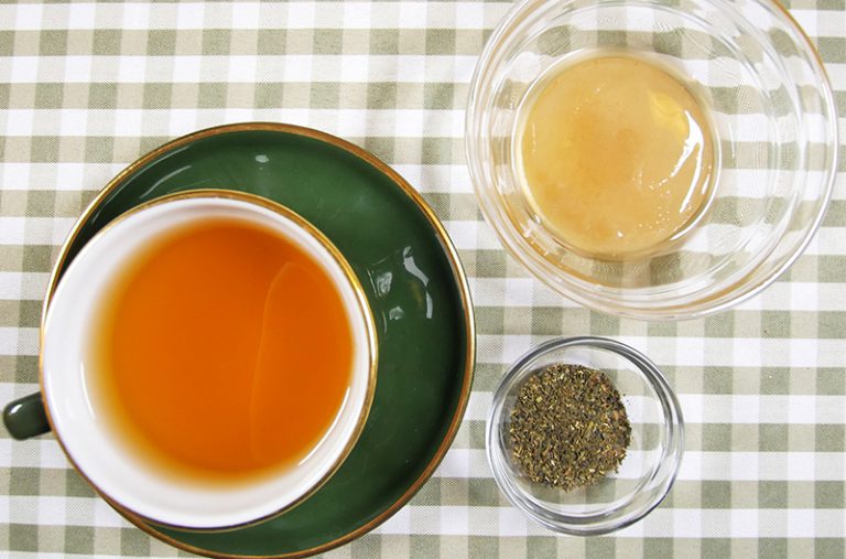 A tea cup with kombucha on a saucer
