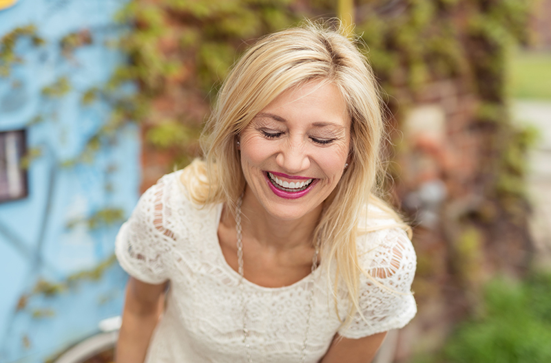 blond woman laughing with eyes closed