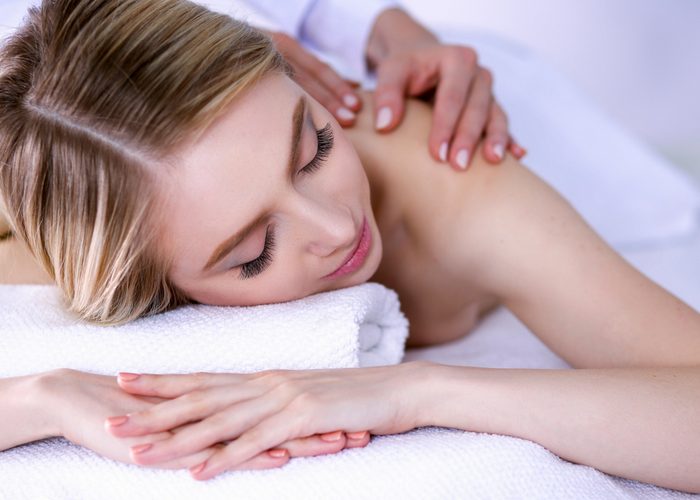 woman lying on table getting a back massage