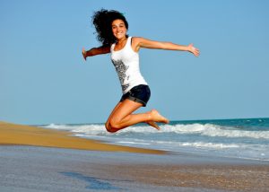happy woman jumping high on a beach