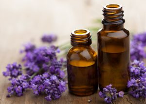 small bottles of lavender oils and purple lavender flowers around