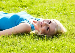 woman lying on the grass in the sun getting vitamin d