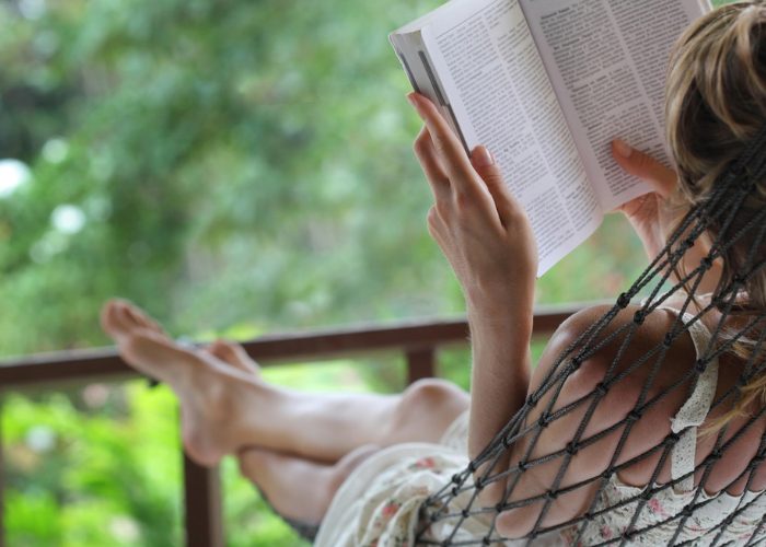 Woman reading a book in a hammock