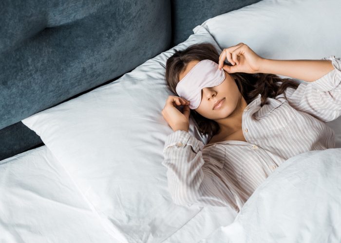 Woman in bed sleeping with eye mask