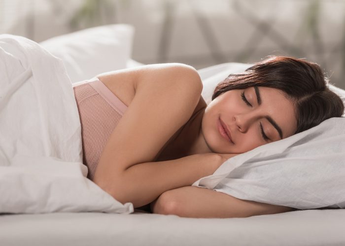Brunette woman sleeping soundly on her side