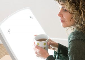 Woman in a sweater holding a cup of hot coffee