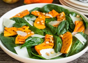 Fresh salad of grilled pumpkin, spinach, and cheese