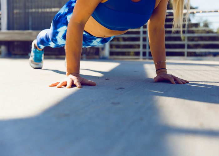 woman in blue workout gear doing pushups
