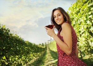 woman enjoying a glass of red wine in a vineyard