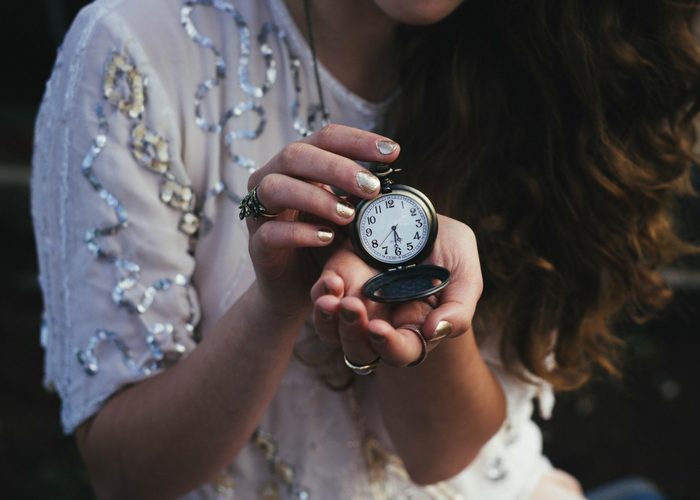 woman holding an antique pocket watch