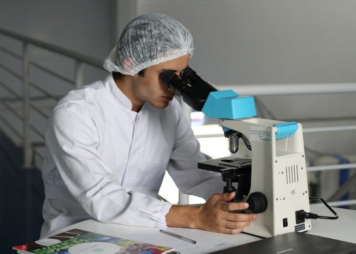 Scientist looking through the microscope researching human pheromones