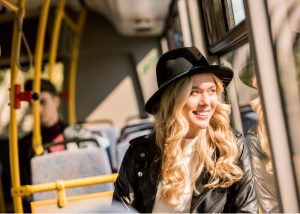 young blonde woman sitting on a bus doing a kegel workout