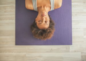 woman lying on a yoga mat focused in her exercise