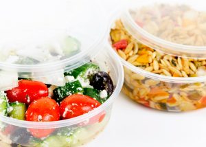 meal delivery containers filled with greek salad and orzo pasta