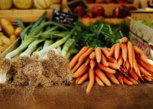 fresh carrots and green onions piled on a cutting board