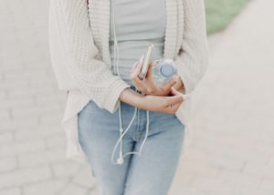 woman walking with a water bottle and cell phone