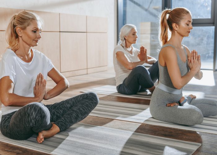 three women of different ages practicing yoga