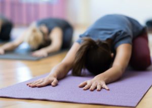 a group of women doing yoga child's pose on yoga mats