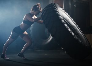woman lifting a large tire in fitness workout
