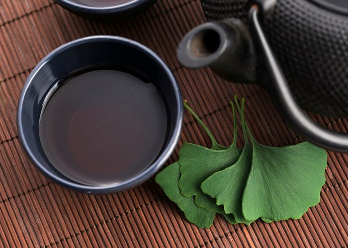 ginkgo biloba tea in a cup and leaves on a table