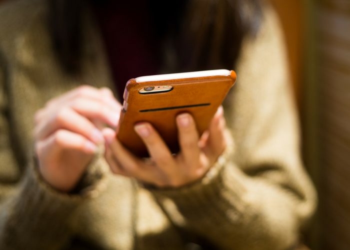 a woman using her smartphone with leather case