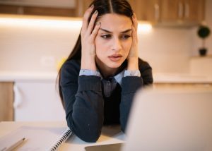 a stressed out woman looking at her laptop