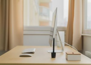 a very clean and organized work table with a monitor, keyboard, mouse, and pen