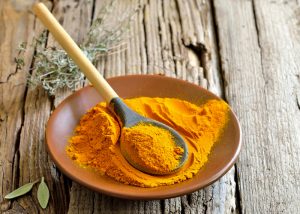 powdered turmeric on a dish with a spoon