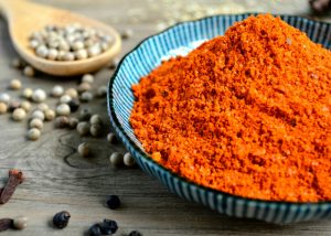a pile of red curry spice on a blue dish