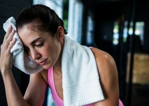 Woman wiping her sweat with a towel at the gym