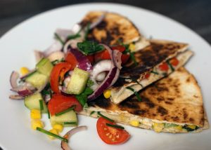 homemade quesadillas filled with vegetables on a white plate
