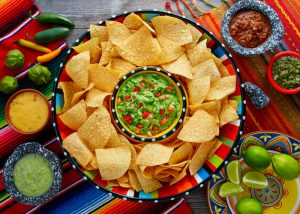 top down view of a big plate of tortilla chips and various dips