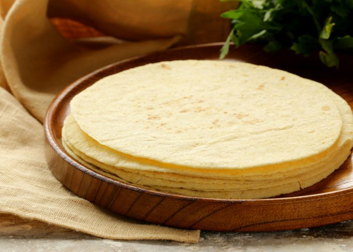 a stack of cassava flour tortillas on a wooden plate