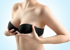 woman in a black bra holding up her breasts