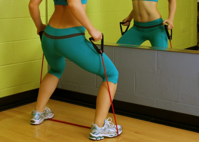 woman doing standing raise chest exercise with resistance bands
