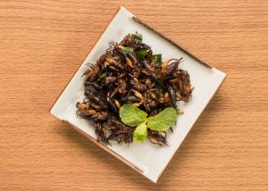 a plate of fried crickets on a wood table