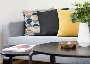 neat and modern living room with round coffee tables and grey couch