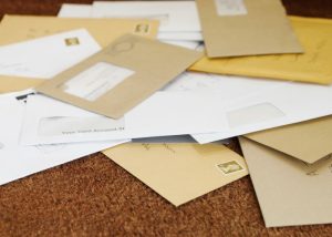 a cluttered pile of mail on a table