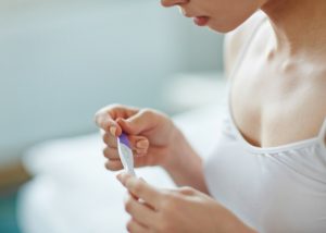 closeup of a woman checking a pregnancy test