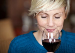 closeup of a woman holding a glass of red wine