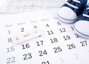 blue baby shoes on a pregnancy calendar