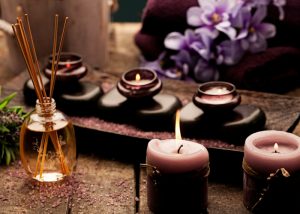 aromatherapy candles and incense with orchids in the background