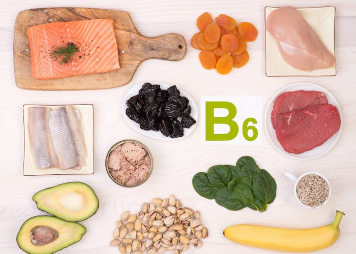 vitamin b6-rich foods such as salmon, apricots, chicken, avocado, banana, and spinach laid out on a table