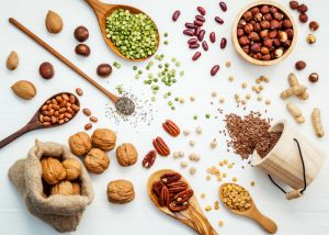 foods rich in vitamin e such as nuts and seeds on a white background