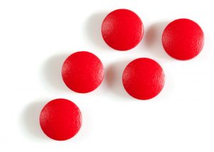 red iron supplement tablets on a white background