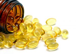 natural vitamin supplement capsules spilling out of a brown bottle